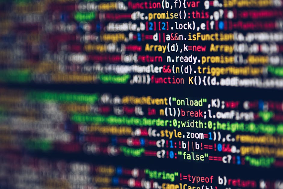 The image features a close-up of a computer screen displaying lines of programming code in various colors, including blue, yellow, orange, and red, with a dark background. The code appears to be JavaS